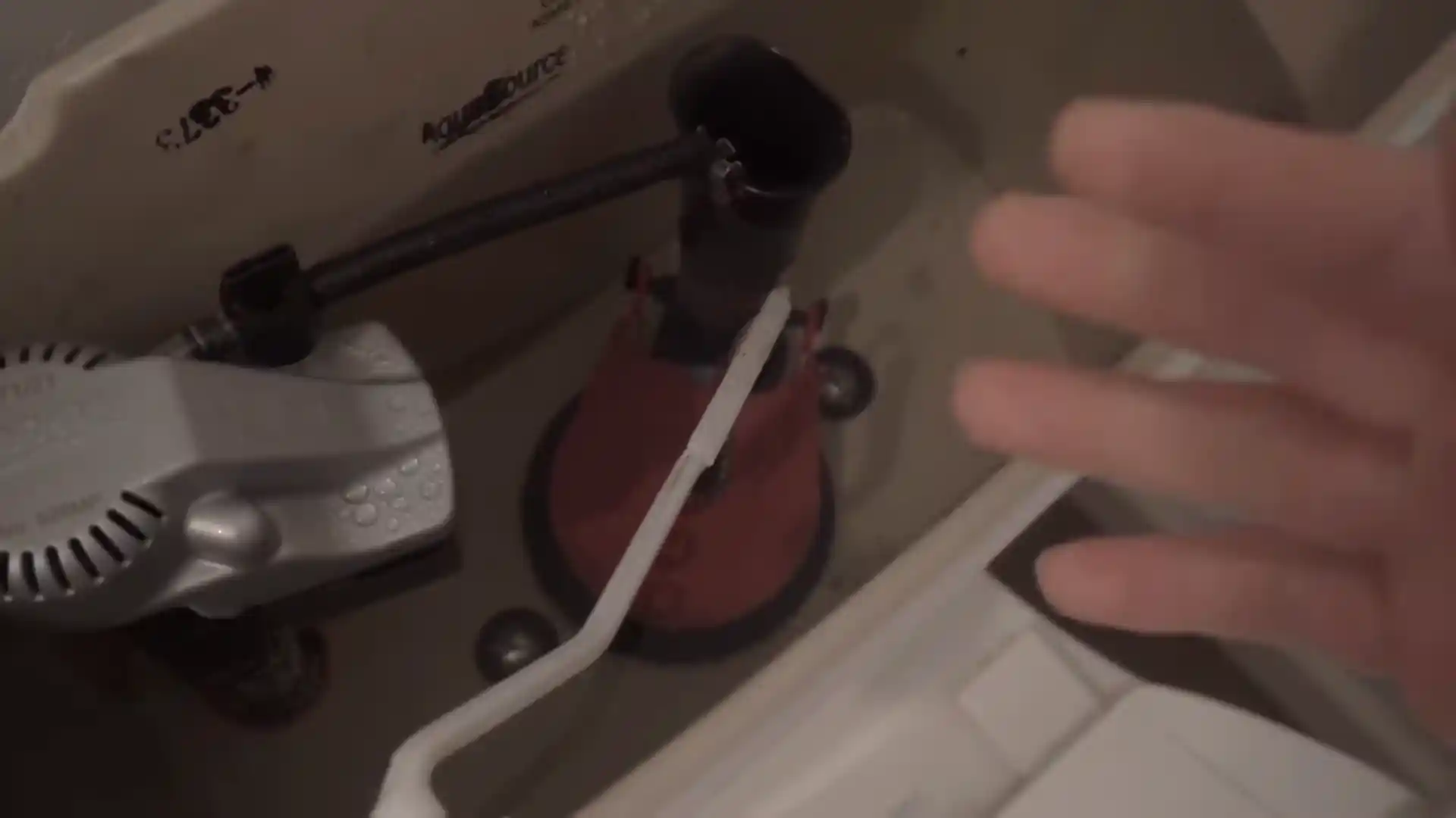 fill valve and flush valve inspection inside a toilet tank in a Stonegate bathroom